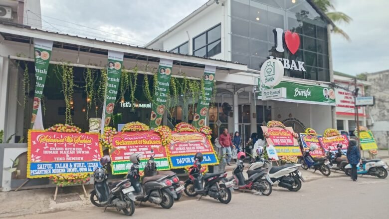 RM Bunda Hadir di Rangkasbitung, Sajikan Cita Rasa Khas dan Suasana Nyaman dengan Fasilitas WiFi Gratis 1 Tampak depan Rumah Makan Bunda Rangkasbitung saat grand opening dengan sejumlah karangan bunga ucapan selamat berjejer di depan bangunan.