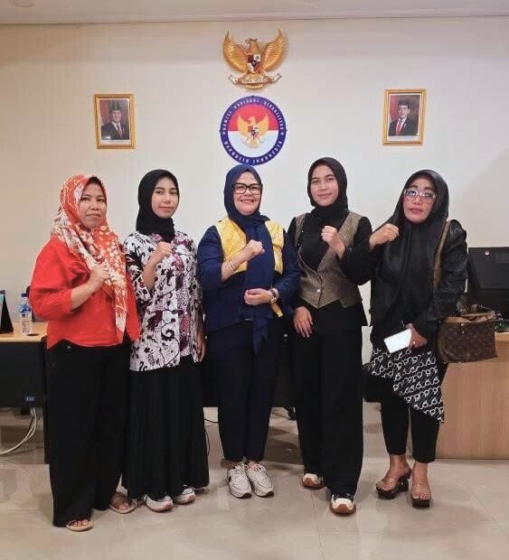 Pendamping Pastikan Kesaksian RU dan SF Benar Adanya: Mereka Punya Hak Didengar 1 Lima perempuan berdiri bersama dengan gestur tangan mengepal di depan lambang Garuda dan simbol lembaga negara, melambangkan solidaritas dalam memperjuangkan hak penyandang disabilitas.